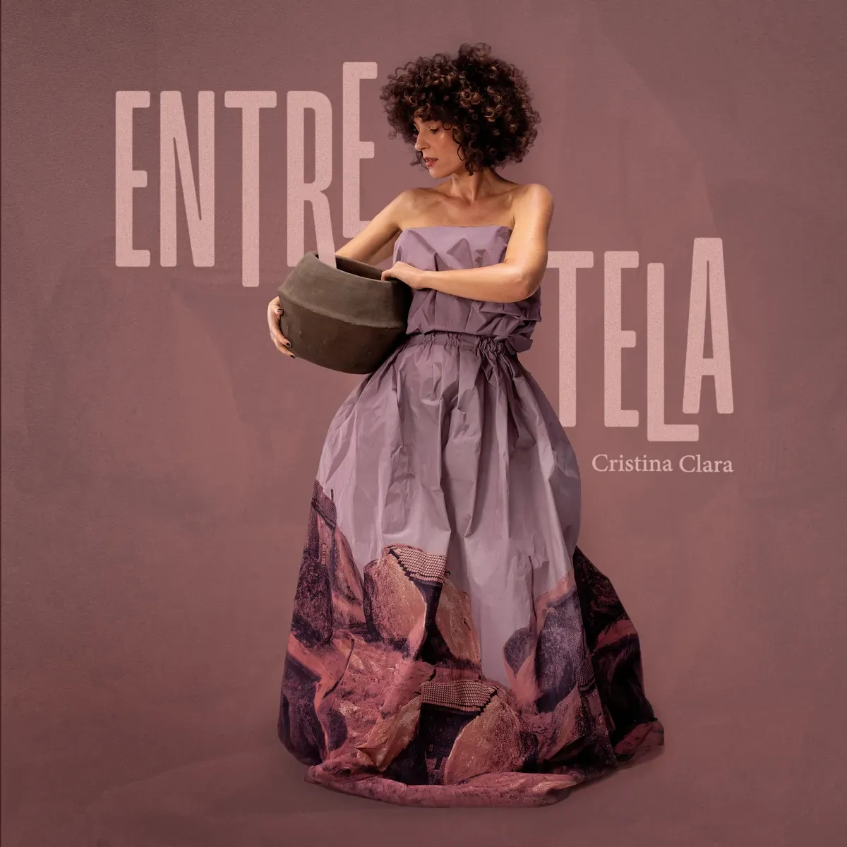 Capa de Entretela: Cristina Clara com um pote de barro e um vestido estampado com rochas